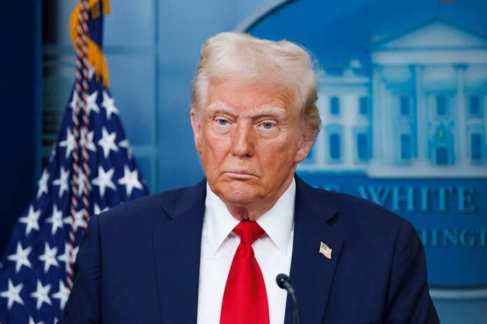 Man in suit with American flag backdrop