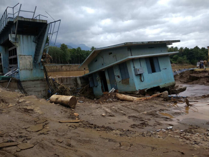 1768175924 A collapsed building and debris in a muddy area after a flood