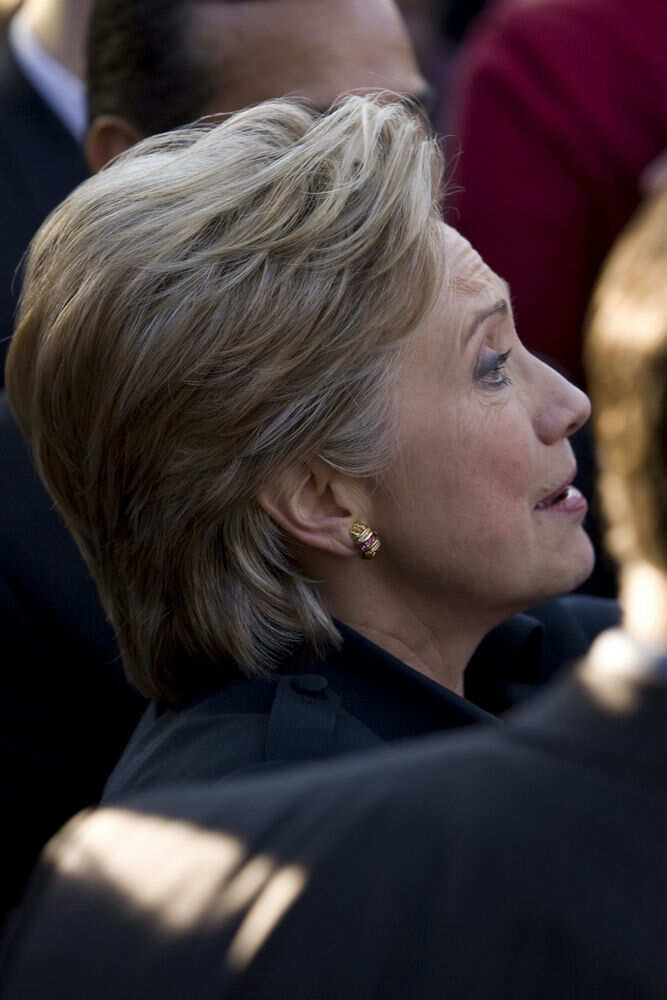 8648599 Person with short blonde hair, wearing gold earrings.