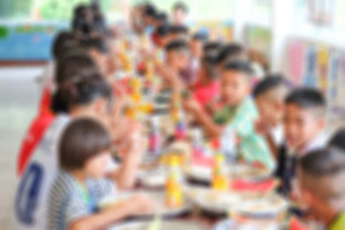 492770809 Children sitting together at a long dining table