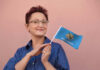 Woman holding an Oklahoma flag and smiling