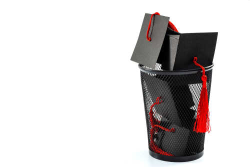 Graduation caps and boxes in a black wastebasket