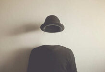 A headless figure wearing a floating hat against a plain background