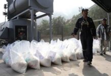 Workers at an industrial site handling large bags of material