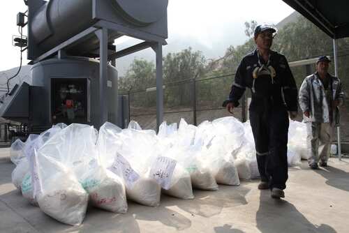 shutterstock_2040333995.jpg Workers at an industrial site handling large bags of material