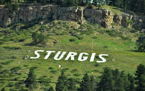 Large white letters spelling 'STURGIS' on a hillside