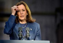 Female politician speaking at a podium with microphones