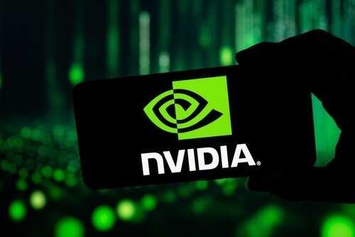 shutterstock_2567705193.jpg Hand holding a smartphone displaying the NVIDIA logo against a backdrop of green lights