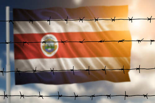 Costa Rican flag partially obscured by barbed wire