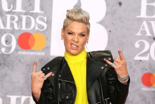 A celebrity making a rock gesture at a music awards event