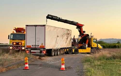 A recovery truck lifting a trailer on a roadside