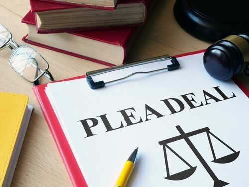 Document titled 'PLEA DEAL' with a gavel and legal books in the background