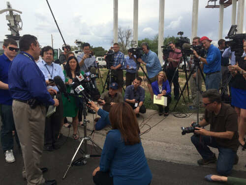 shutterstock_1454828273 (1).jpg A group of journalists gathered for a press conference with a speaker at a podium