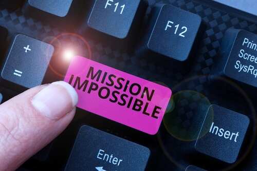 A finger pressing a pink key labeled 'MISSION IMPOSSIBLE' on a keyboard