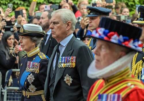 Members of the royal family and officials in military uniforms during a public ceremony