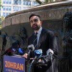 A man giving a speech at a podium in a city park