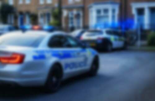 Two police cars parked on a residential street with flashing lights