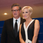 Two media personalities posing together at a conference