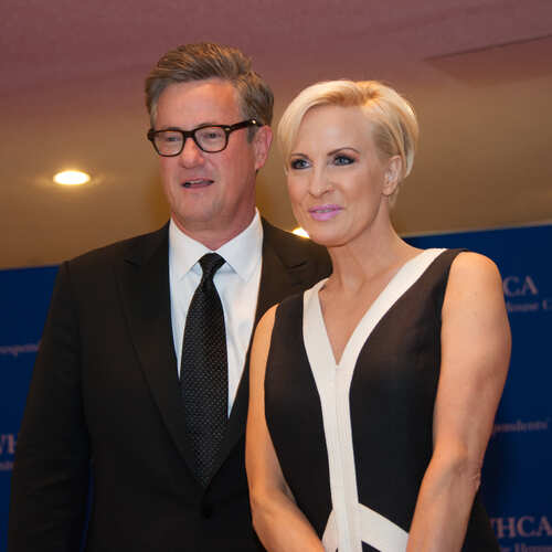 Two media personalities posing together at a conference