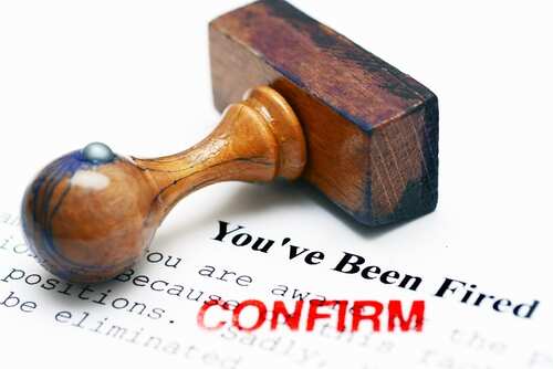 Rubber stamp on a termination notice with the words 'You've Been Fired' and 'CONFIRM'