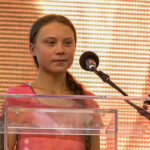 Young activist speaking at a podium with a microphone