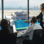 Air traffic controllers monitoring flight data in a control room