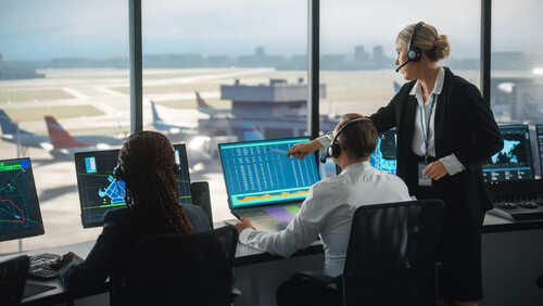 Air traffic controllers monitoring flight data in a control room