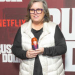 A woman holding a doll at a promotional event for a Netflix series