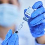 Healthcare professional preparing a COVID-19 vaccine with a syringe