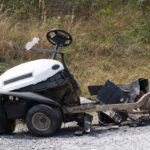 An abandoned lawn mower left on gravel ground
