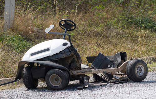 An abandoned lawn mower left on gravel ground