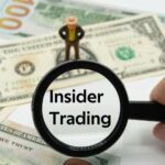 A magnifying glass focusing on the words 'Insider Trading' with a figure standing on dollar bills