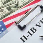 H-1B visa document on a table with US flag and dollar bills