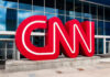 Red CNN logo outside glass building entrance