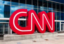 Red CNN logo outside glass building entrance