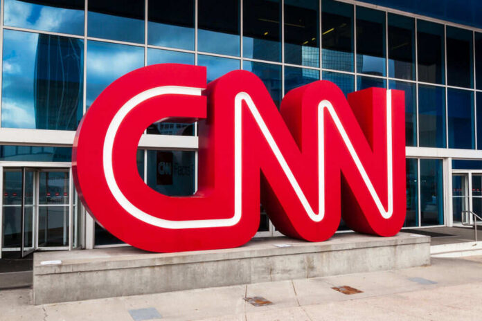Red CNN logo outside glass building entrance