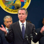 Man speaking at podium with people behind him