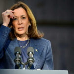 Woman speaking at podium with microphones outdoors
