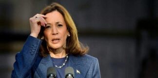 Woman speaking at podium with microphones outdoors
