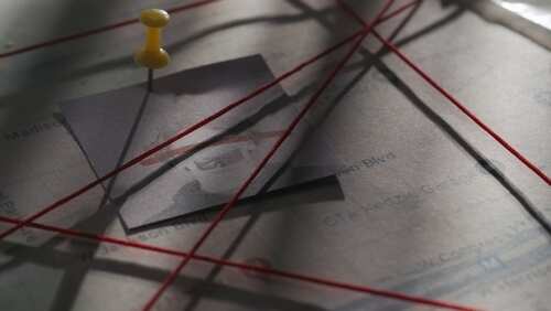 shutterstock_2406412443.jpg A corkboard with a photo pinned and red strings connecting various points