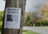 Missing person poster on a telephone pole with a woman's photo