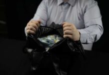 Person opening a black bag filled with cash