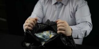 Person opening a black bag filled with cash