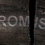 Close-up of a cracked wooden surface with the word 'PROMISE' visible