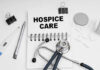 Notebook with 'HOSPICE CARE' written on it, surrounded by medical tools