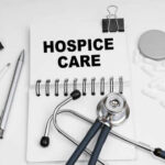 Notebook with 'HOSPICE CARE' written on it, surrounded by medical tools
