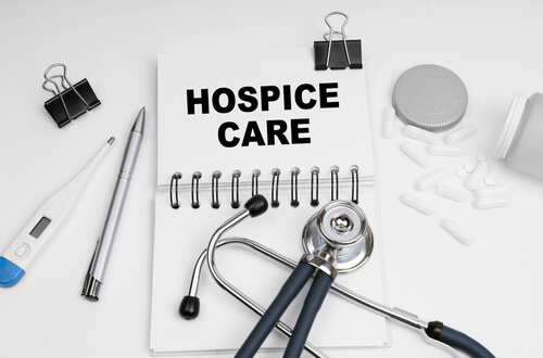 Notebook with 'HOSPICE CARE' written on it, surrounded by medical tools