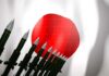 A row of military missiles in front of the Japanese flag