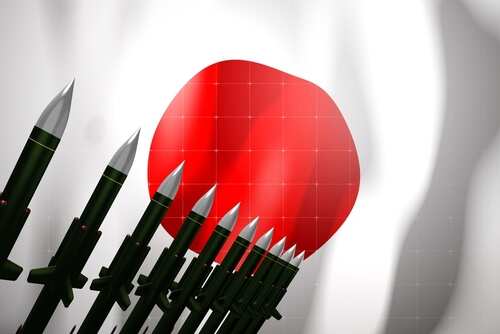 A row of military missiles in front of the Japanese flag