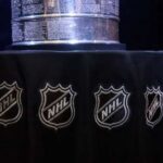 Close-up of the Stanley Cup displayed on a black tablecloth with NHL logos